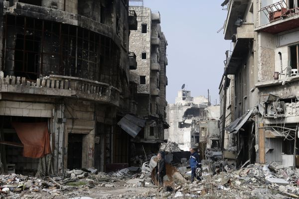 Syrians walk through the destruction in the old city of Aleppo, Syria - Sputnik International