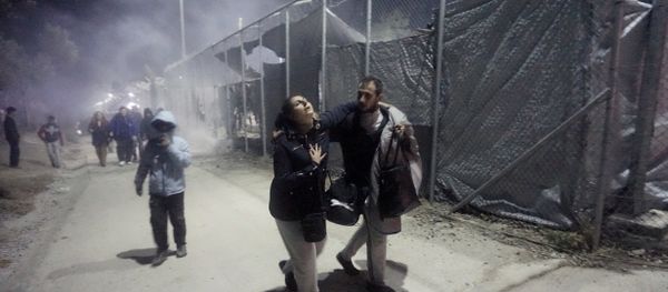 Migrants leave Moria camp following an explosion and fire on the island of Lesbos early on November 25, 2016. Angry migrants set fire to a camp on the Greek island of Lesbos after a woman and a six-year-old child died following a gas cylinder explosion, local police said. Migrants leave Moria camp following an explosion and fire on the island of Lesbos early on November 25, 2016. Angry migrants set fire to a camp on the Greek island of Lesbos after a woman and a six-year-old child died following a gas cylinder explosion, local police said. - Sputnik International