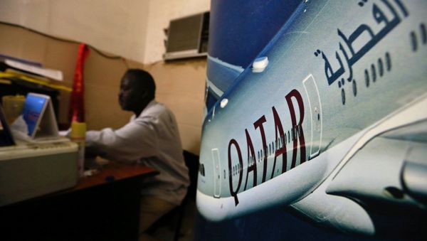 An image of a Qatar Airways plane is seen near an employee working at a travel agency in Khartoum, Sudan January 28, 2017 - Sputnik International