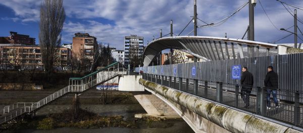People walk on the main bridge of the town of Mitrovica People walk on the main bridge of the town of Mitrovica - Sputnik International