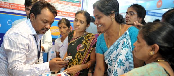 An Indian bank employee (L) explains to visitors about account transactions from a mobile phone with a Aadhaar or Unique Identification (UID) card during a Digi Dhan Mela, held to promote digital payment, in Hyderabad on January 18, 2017 An Indian bank employee (L) explains to visitors about account transactions from a mobile phone with a Aadhaar or Unique Identification (UID) card during a Digi Dhan Mela, held to promote digital payment, in Hyderabad on January 18, 2017 - Sputnik International
