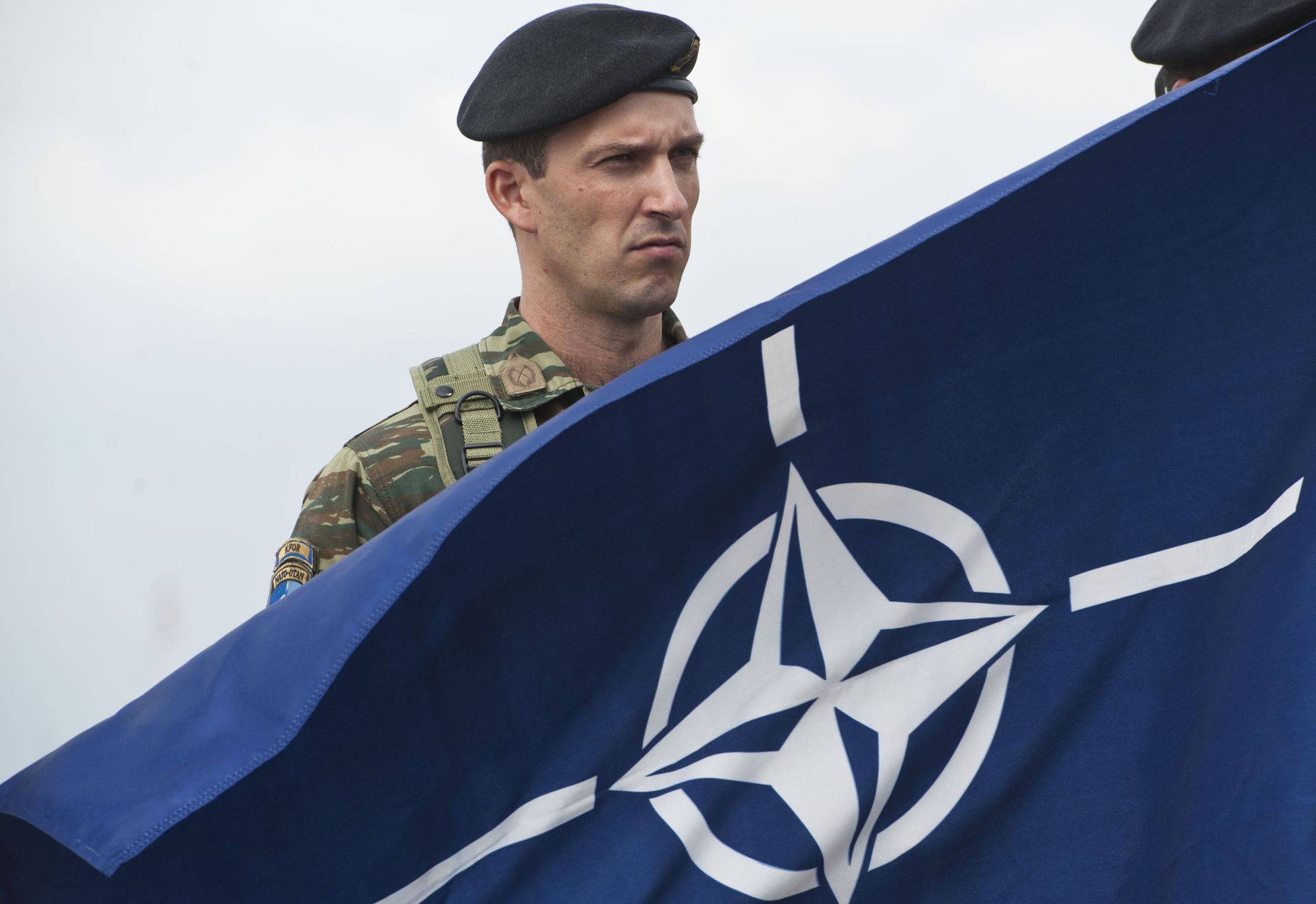 A members of NATO-led peacekeepers in Kosovo (KFOR) holds the NATO flag during the change of command ceremony in Pristina on September 3, 2014. A members of NATO-led peacekeepers in Kosovo (KFOR) holds the NATO flag during the change of command ceremony in Pristina on September 3, 2014. - Sputnik International, 1920, 22.11.2022
