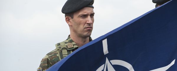 A members of NATO-led peacekeepers in Kosovo (KFOR) holds the NATO flag during the change of command ceremony in Pristina on September 3, 2014. A members of NATO-led peacekeepers in Kosovo (KFOR) holds the NATO flag during the change of command ceremony in Pristina on September 3, 2014. - Sputnik International