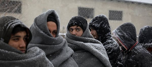 Migrants wait in line to receive free food during a snowfall outside a derelict customs warehouse in Belgrade, Serbia January 9, 2017. - Sputnik International