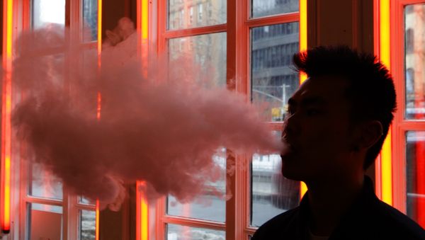 Man exhales vapor from an e-cigarette Man exhales vapor from an e-cigarette - Sputnik International