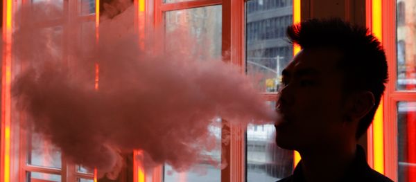 Man exhales vapor from an e-cigarette Man exhales vapor from an e-cigarette - Sputnik International
