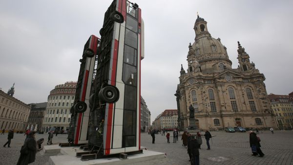 People walk next to the art instalation Monument by Syrian artist Manaf Halbouni, made from three passenger busses in Dresden, Germany February 8, 2017. - Sputnik International