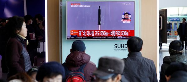 Passengers watch a TV screen broadcasting a news report on North Korea firing a ballistic missile into the sea off its east coast, at a railway station in Seoul, South Korea, February 12, 2017 - Sputnik International