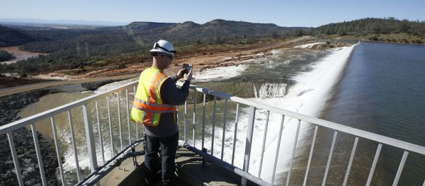 In this Saturday, Feb. 11, 2017, photo, Jason Newton, of the Department of Water Resources, takes a picture of water going over the emergency spillway at Oroville Dam in Oroville, Calif - Sputnik International