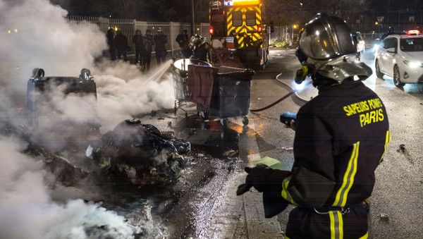 Firefighters extinguish garbage containers set ablaze during the unrest following a protest against police brutality in the Paris suburb of Bobigny. file photo - Sputnik International