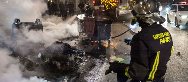 Firefighters extinguish garbage containers set ablaze during the unrest following a protest against police brutality in the Paris suburb of Bobigny. file photo Firefighters extinguish garbage containers set ablaze during the unrest following a protest against police brutality in the Paris suburb of Bobigny. file photo - Sputnik International