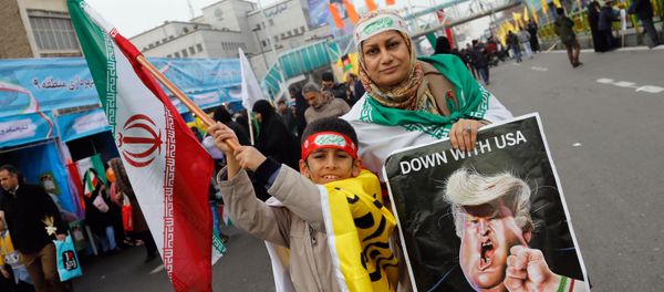 An Iranian woman holds a placard showing a caricature of US President Donald Trump being punched by a hand wearing a bracelet of the Iranian flag during a rally marking the anniversary of the 1979 Islamic revolution on February 10, 2017, in the capital Tehran An Iranian woman holds a placard showing a caricature of US President Donald Trump being punched by a hand wearing a bracelet of the Iranian flag during a rally marking the anniversary of the 1979 Islamic revolution on February 10, 2017, in the capital Tehran - Sputnik International