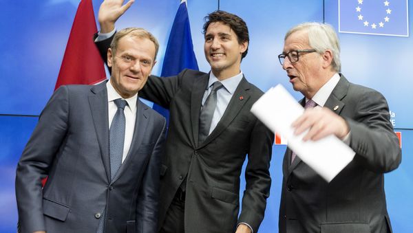 European Council President Donald Tusk, left, Canadian Prime Minister Justin Trudeau, center, and European Commission President Jean-Claude Juncker prepare to leave the room at the end of an EU-Canada summit at the European Council building in Brussels, Sunday, Oct. 30, 2016. - Sputnik International