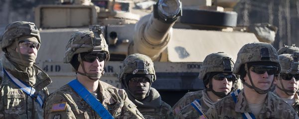 Members of US Army's 4th Infantry Division 3rd Brigade Combat Team 68th Armor Regiment 1st Battalion stand in front of an Abrams battle tank after arriving at the Gaiziunai railway station, some 110 kms (69 miles) west of the capital Vilnius, Lithuania, Friday, Feb. 10, 2017. - Sputnik International