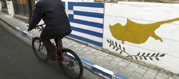 A man passes with a bicycle outside of a Greek Cypriot guard post with Cyprus', right, and Greece' flags painted on the wall in central divided capital Nicosia in the eastern Mediterranean island of Cyprus, on Thursday, Feb. 16, 2017. A man passes with a bicycle outside of a Greek Cypriot guard post with Cyprus', right, and Greece' flags painted on the wall in central divided capital Nicosia in the eastern Mediterranean island of Cyprus, on Thursday, Feb. 16, 2017. - Sputnik International