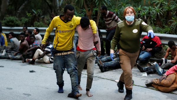 African migrants help each other as they arrive at the CETI, the short-stay immigrant centre, after crossing the border from Morocco to Spain's North African enclave of Ceuta, Spain, February 17, 2017 - Sputnik International