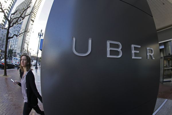 In this file photo taken Tuesday, Dec. 16, 2014, a woman walks past the company logo of the internet car service, Uber, in San Francisco, USA.  - Sputnik International