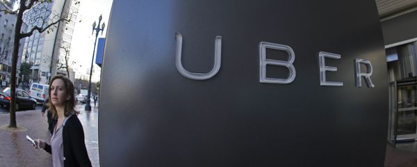 In this file photo taken Tuesday, Dec. 16, 2014, a woman walks past the company logo of the internet car service, Uber, in San Francisco, USA. In this file photo taken Tuesday, Dec. 16, 2014, a woman walks past the company logo of the internet car service, Uber, in San Francisco, USA. - Sputnik International