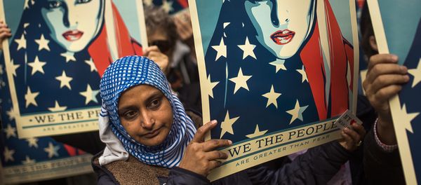 People carry posters during a rally against President Donald Trump's executive order banning travel from seven Muslim-majority nations, in New York's Times Square, Sunday, Feb. 19, 2017. - Sputnik International