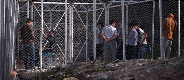 Migrants stand behind a fence at the VIAL detention center on the island of Chios where migrants and refugees arrived after the March 20 EU-Turkey deal are kept, on April 4, 2016 Migrants stand behind a fence at the VIAL detention center on the island of Chios where migrants and refugees arrived after the March 20 EU-Turkey deal are kept, on April 4, 2016 - Sputnik International