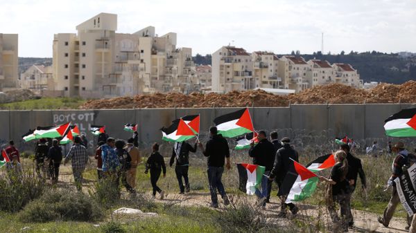 Palestinians and foreigners march towards Israel's controversial separation wall between the West Bank village of Bilin near Ramallah and the Israeli settlement of Modiin Ilit during a demonstration against settlements in the area, on February 17, 2017 - Sputnik International