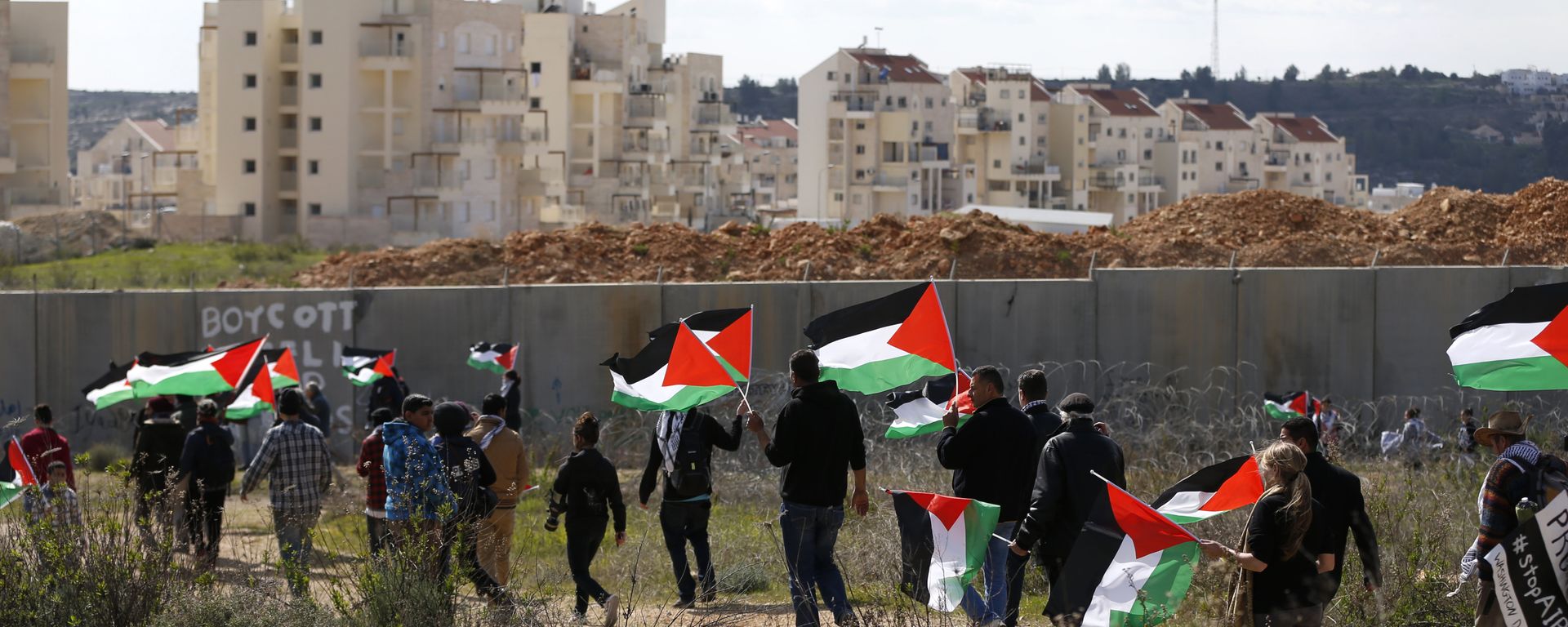 Palestinians and foreigners march towards Israel's controversial separation wall between the West Bank village of Bilin near Ramallah and the Israeli settlement of Modiin Ilit during a demonstration against settlements in the area, on February 17, 2017 Palestinians and foreigners march towards Israel's controversial separation wall between the West Bank village of Bilin near Ramallah and the Israeli settlement of Modiin Ilit during a demonstration against settlements in the area, on February 17, 2017 - Sputnik International, 1920, 22.02.2017