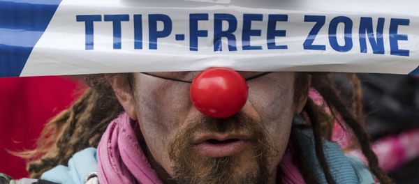 A man covers his eyes with a banner as he protests against international trade agreements TTIP and CETA in front of EU headquarters in Brussels on Thursday, Oct. 27, 2016 - Sputnik International