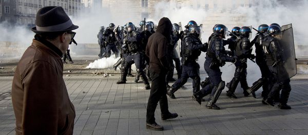 A man looks at riot police throwing tear gas while protesters demonstrate against the visit of French presidential election candidate for the far-right Front National (FN) party, on February 25, 2017 in Nantes, western France. - Sputnik International