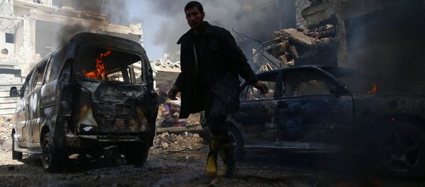 A civil defence member works amid burning vehicles at a site hit by airstrikes in the rebel held besieged Douma neighbourhood of Damascus, Syria, February 26, 2017. - Sputnik International