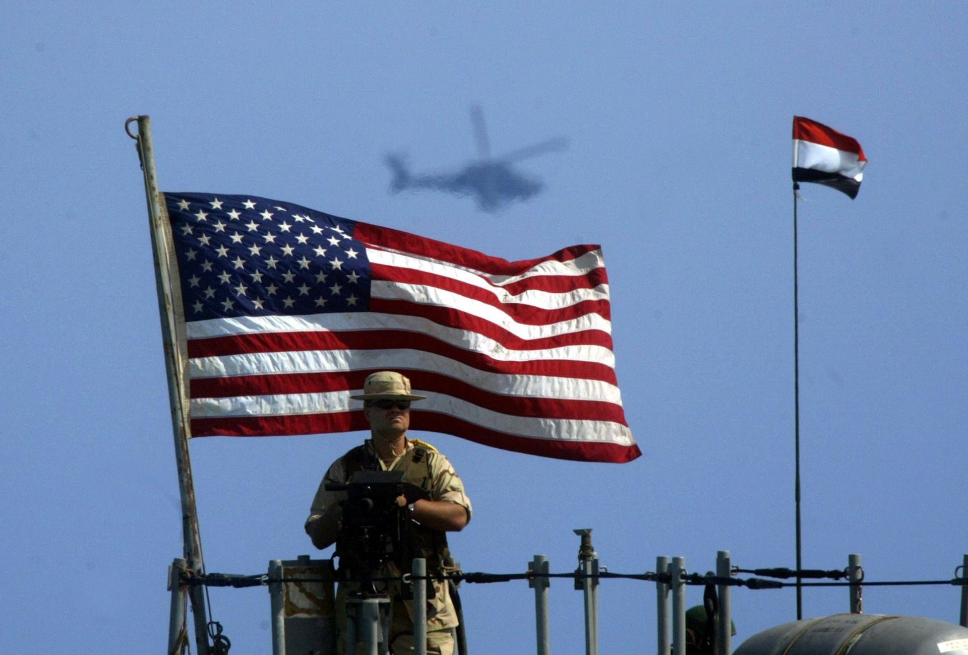 A US Navy member mans his gun as a Cobra helicopter hovers during the Bright Star joint war games that involves 30,000 troops from 12 countries off the coast of Egypt's northern El-Alamein region (file) - Sputnik International, 1920, 25.07.2022