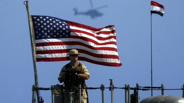 A US Navy member mans his gun as a Cobra helicopter hovers during the Bright Star joint war games that involves 30,000 troops from 12 countries off the coast of Egypt's northern El-Alamein region (file) - Sputnik International