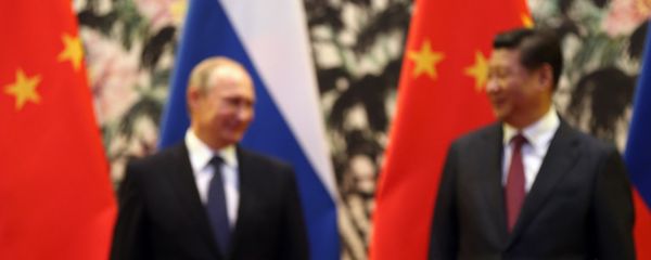 The Russian and Chinese national flags are seen on the table as Russia's President Vladimir Putin (back L) and his China's President Xi Jinping (back R) stand during a signing ceremony at the Diaoyutai State Guesthouse in Beijing on November 9, 2014. - Sputnik International