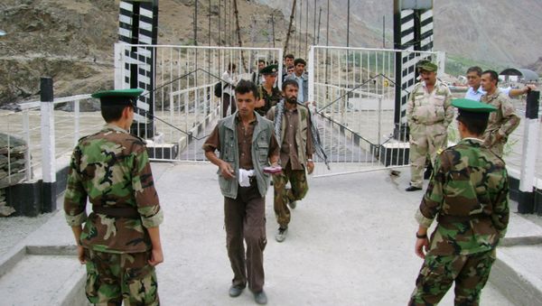 Tajik border guards checking identification documents of people crossing the Tajik-Afghan border on a bridge across the Panj River outside the city of Panj - Sputnik International