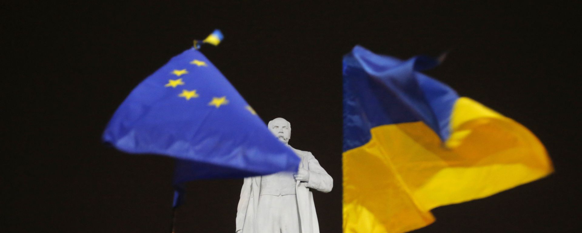 In this Thursday, Dec. 5, 2013 photo opposition protesters holds hold the EU and Ukrainian, right, flags around a monument to Ukrainian poet Taras Shevchenko in downtown Donetsk, eastern Ukraine. - Sputnik International, 1920, 19.08.2025