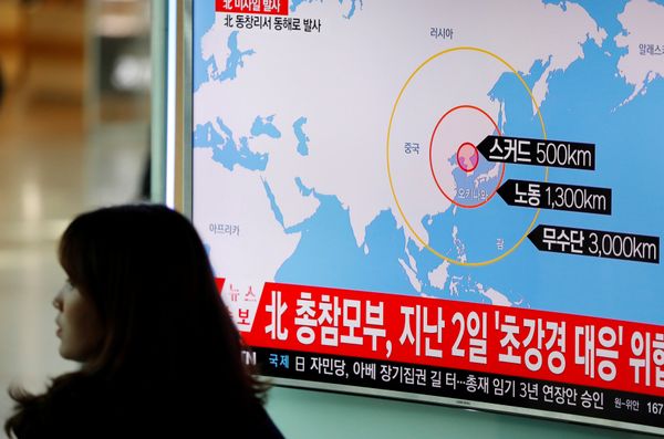 A woman walks past a television broadcasting a news report on North Korea firing ballistic missiles, at a railway station in Seoul, South Korea, March 6, 2017. - Sputnik International