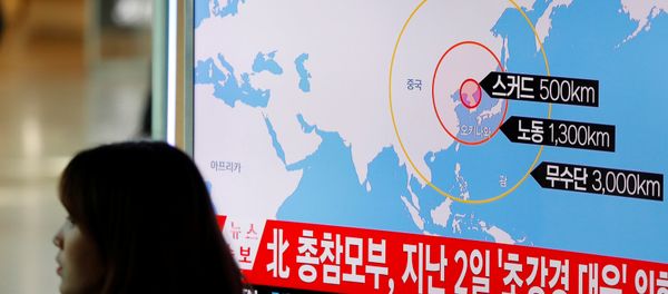 A woman walks past a television broadcasting a news report on North Korea firing ballistic missiles, at a railway station in Seoul, South Korea, March 6, 2017. - Sputnik International
