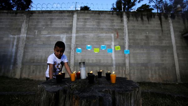 Candles are lit for victims after a fire broke out at the Virgen de Asuncion home in San Jose Pinula on the outskirts of Guatemala City, March 8, 2017 - Sputnik International