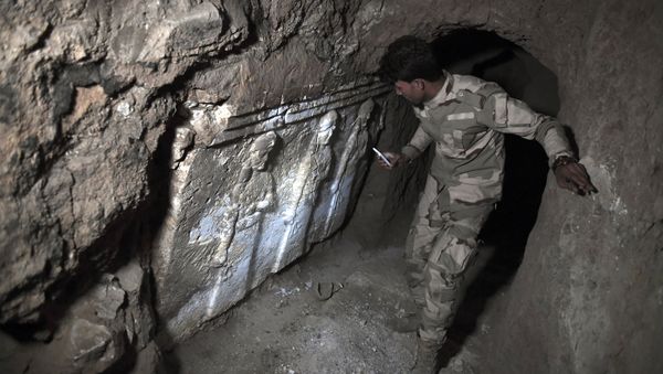 A member of the Iraqi troops stands next to archeological findings inside an underground tunnel in east Mosul on March 6, 2017 A member of the Iraqi troops stands next to archeological findings inside an underground tunnel in east Mosul on March 6, 2017 - Sputnik International