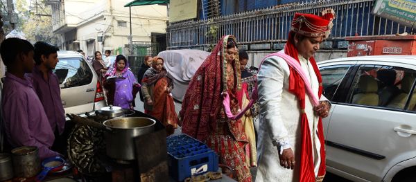 Newly married Indian man Rohit Aggarwal (R) is watched by relatives and street vendors as he leads his wife Shally Aggarwal (2R) to their home after visiting a temple in New Delhi on February 16, 2017 Newly married Indian man Rohit Aggarwal (R) is watched by relatives and street vendors as he leads his wife Shally Aggarwal (2R) to their home after visiting a temple in New Delhi on February 16, 2017 - Sputnik International