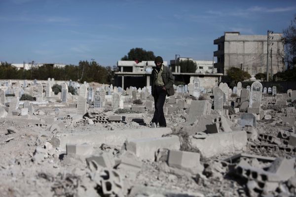 A man walks in a graveyard near destroyed graves in a neighbourhood heavily damaged by air strikes in the village of Deir al-Asafir in the rebel-held region of Eastern Ghouta, on the outskirts of the Syrian capital Damascus (File) - Sputnik International