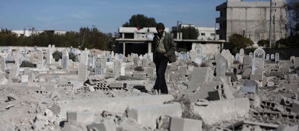 A man walks in a graveyard near destroyed graves in a neighbourhood heavily damaged by air strikes in the village of Deir al-Asafir in the rebel-held region of Eastern Ghouta, on the outskirts of the Syrian capital Damascus (File) - Sputnik International
