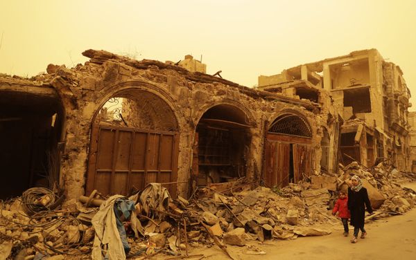 Syrian girls walk past destruction during a sandstorm in the once rebel-held Bab al-Nasr neighbourhood in the old part of Aleppo on March 10, 2017 - Sputnik International