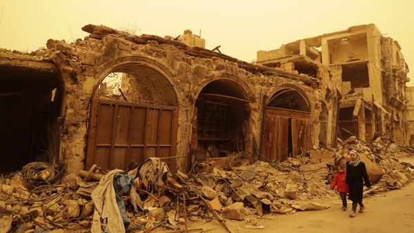 Syrian girls walk past destruction during a sandstorm in the once rebel-held Bab al-Nasr neighbourhood in the old part of Aleppo on March 10, 2017 - Sputnik International