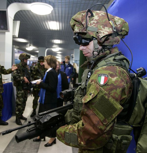 An Italian soldier displays his country's new army weapon during an Army Equipment exhibition on the sideline of the NATO summit in Riga, Latvia. File photo  - Sputnik International