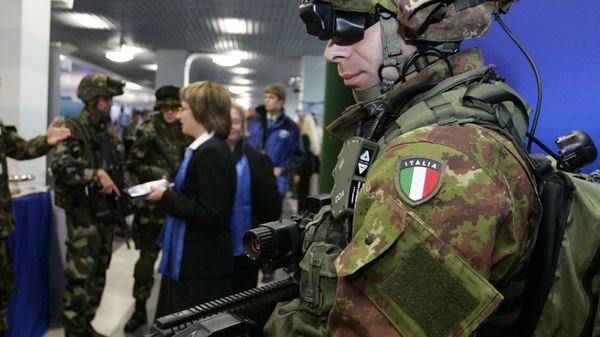 An Italian soldier displays his country's new army weapon during an Army Equipment exhibition on the sideline of the NATO summit in Riga, Latvia. File photo  - Sputnik International