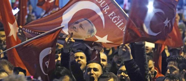 Demonstrators with banners of Turkish President Recep Tayyip Erdogan gather outsidethe Turkish consulate to welcome the Turkish Family Minister Fatma Betul Sayan Kaya, who decided to travel to Rotterdam by land after Turkish Foreign Minister Mevlut Cavusoglu's flight was barred from landing by the Dutch government, in Rotterdam, Netherlands March 11, 2017. - Sputnik International