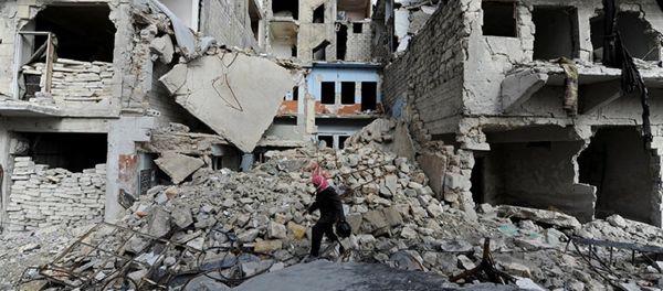 A man walks near damaged buildings in Aleppo, Syria - Sputnik International