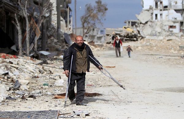 Syrian man walking past damaged buildings in Aleppo  - Sputnik International