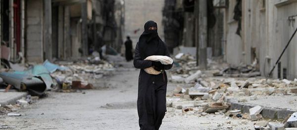 Syrian woman walks past a destroyed building in Aleppo - Sputnik International