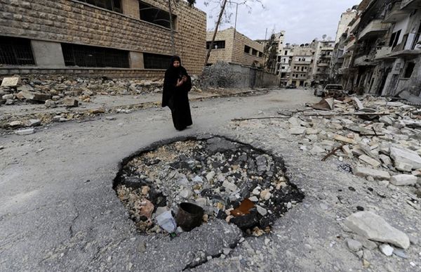 Syrian woman walks past a destroyed building in Aleppo - Sputnik International